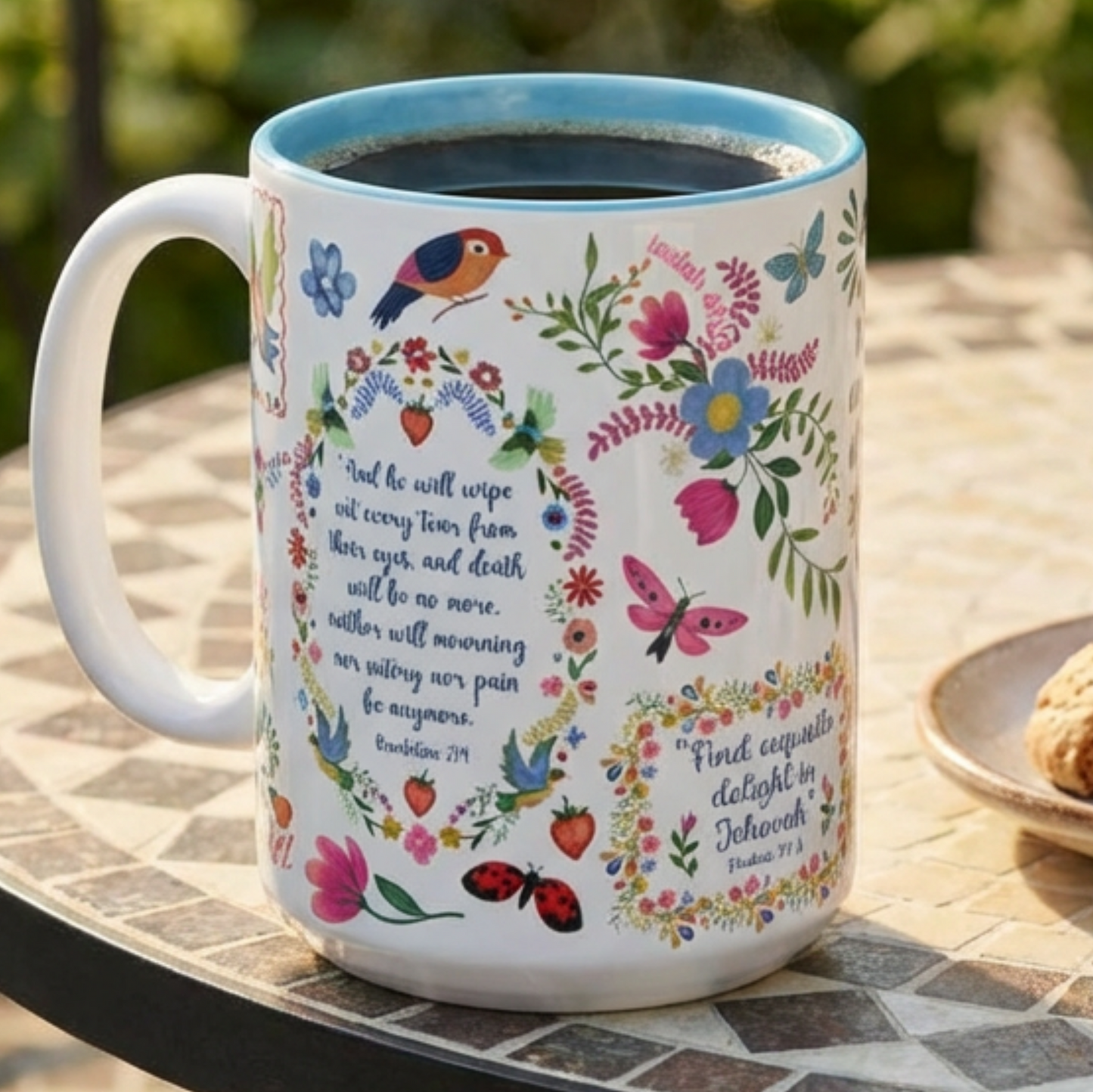 Decorative Bible Verse mug with floral designs and text on a table outdoors
